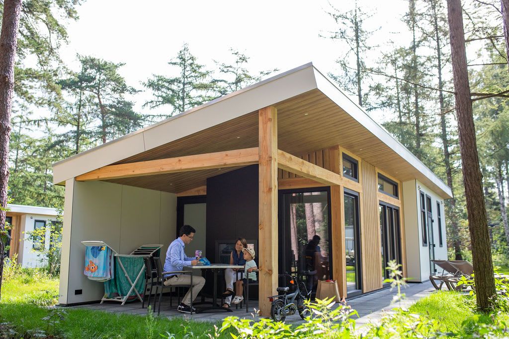 Geniet van de rust op het terras van Bungalow Molenstein, een vakantiehuis in Doorn, Utrechtse Heuvelrug, omgeven door groene natuur.