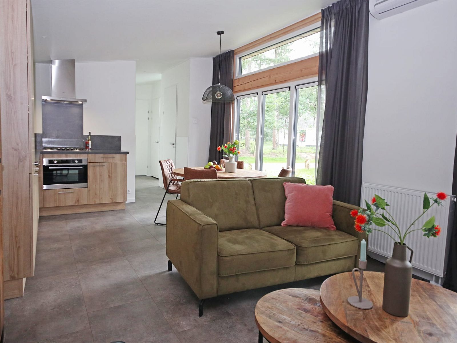 Gezellige woonkamer van Bungalow Molenstein in Doorn, Utrechtse Heuvelrug, met modern interieur en uitzicht op de groene omgeving.