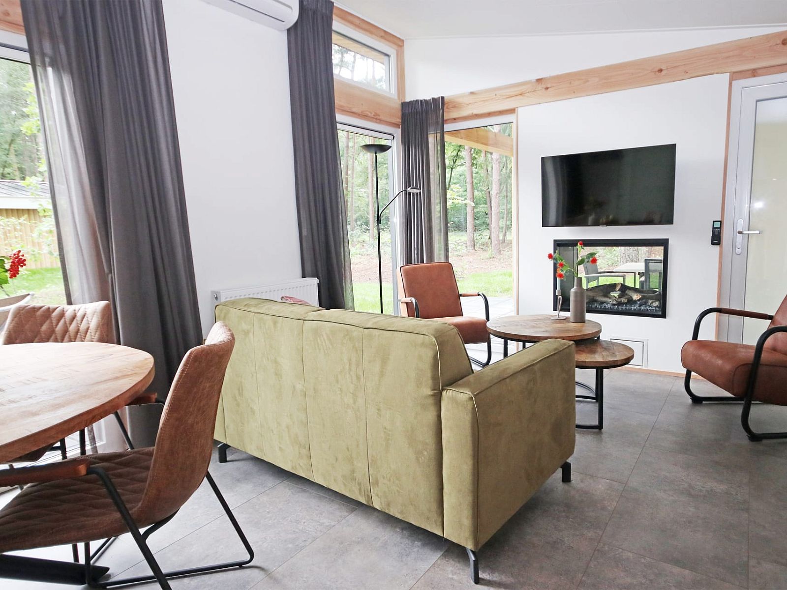 Gezellige woonkamer in Bungalow Molenstein, Doorn, Utrechtse Heuvelrug, met uitzicht op de natuur en moderne inrichting.