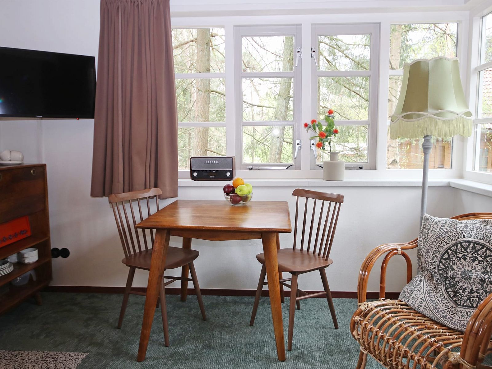 Eethoek in Bungalow Ficus, Doorn, Utrechtse Heuvelrug, met houten tafel en uitzicht op bosrijke omgeving.