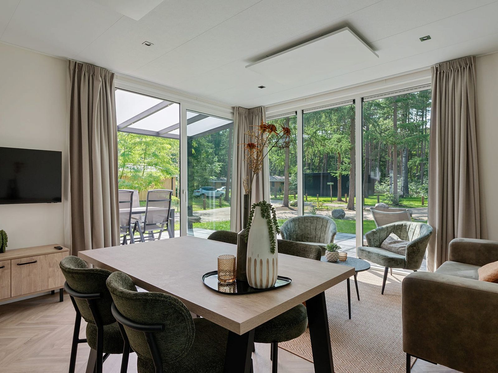 Bright living space in Bungalow Noordhout, Doorn, with large windows and nature view of the Utrechtse Heuvelrug.