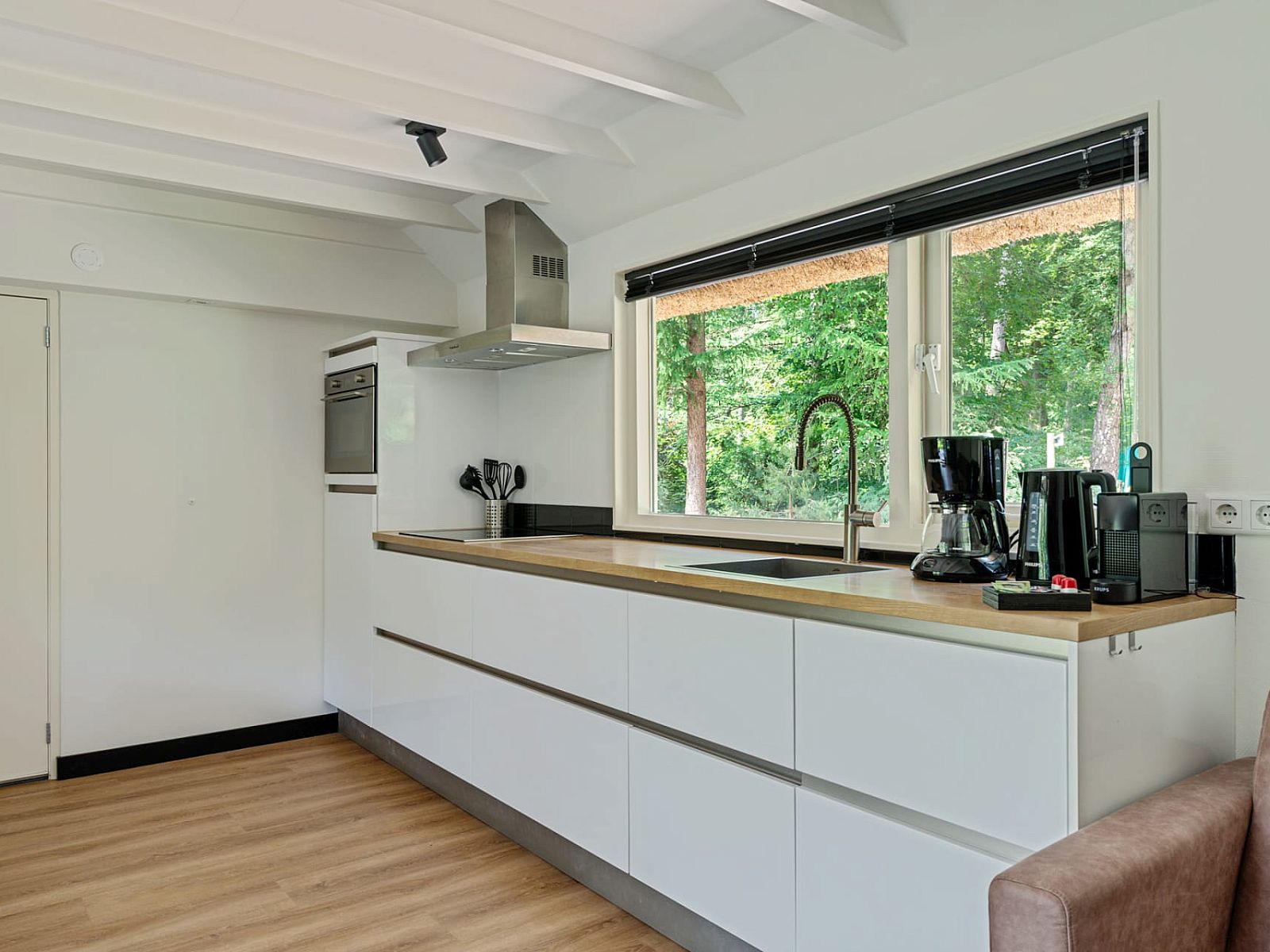 Kitchen with a view of nature in Bungalow Dennenburg, Doorn, Utrechtse Heuvelrug.