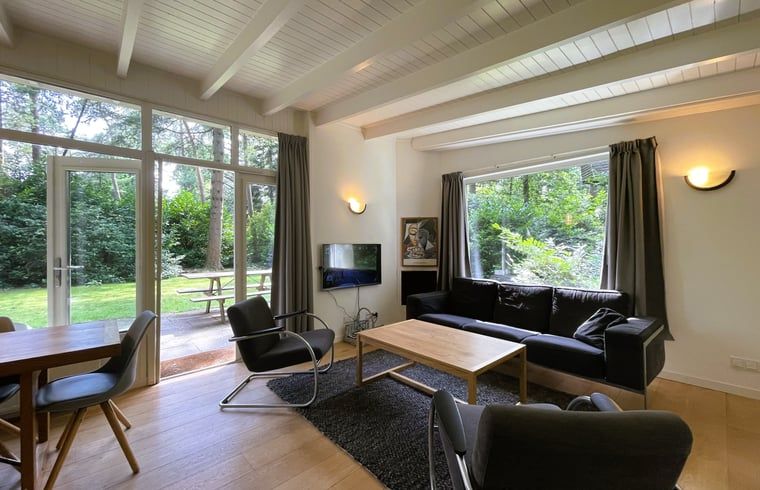Cozy living room of Holiday Home in Maarn, Utrechtse Heuvelrug, overlooking the green garden.