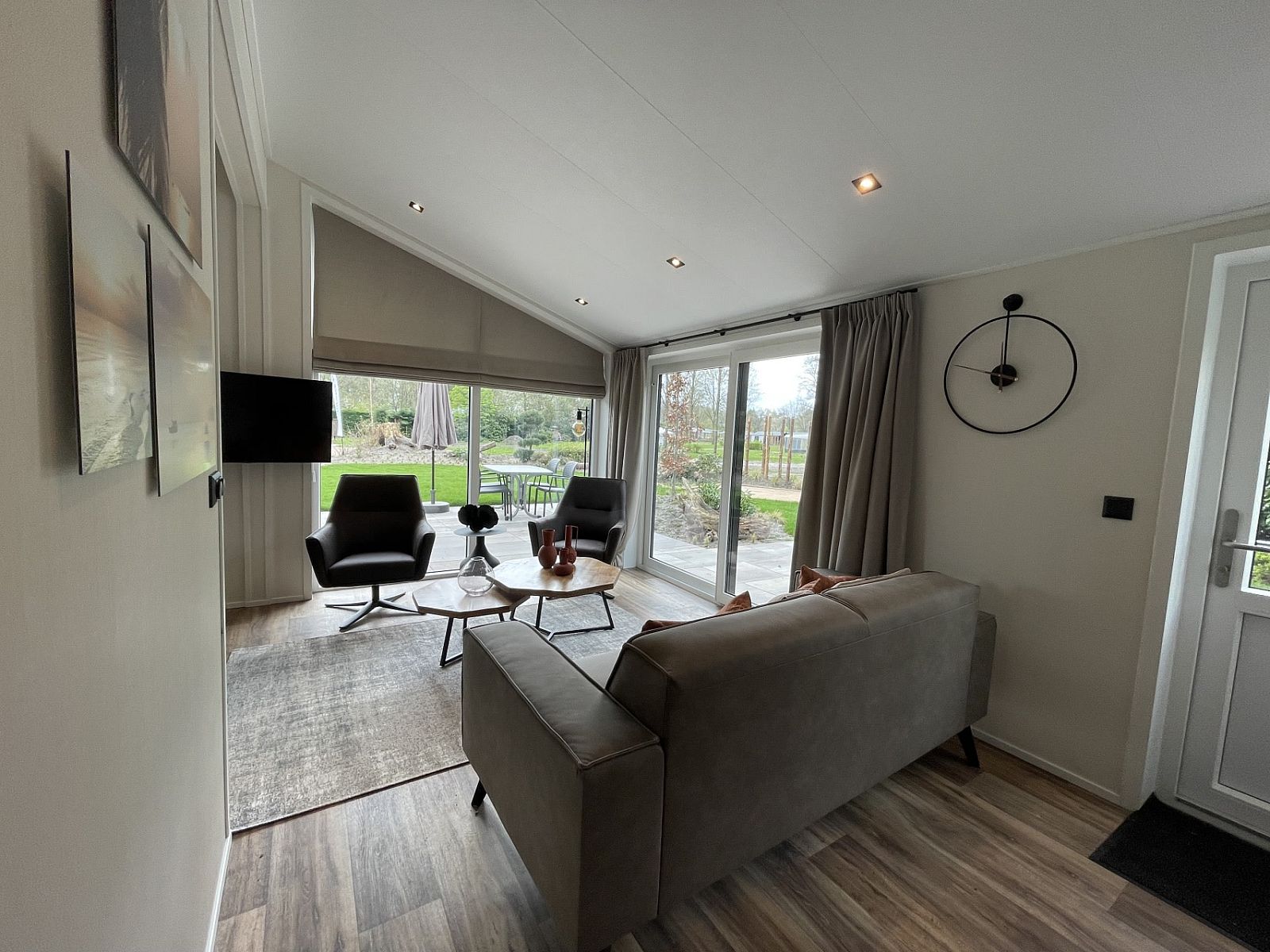 Gemtliches Wohnzimmer im Chalet in Maarn, Utrechtse Heuvelrug, mit Blick auf den Garten von der bequemen Sitzecke aus.