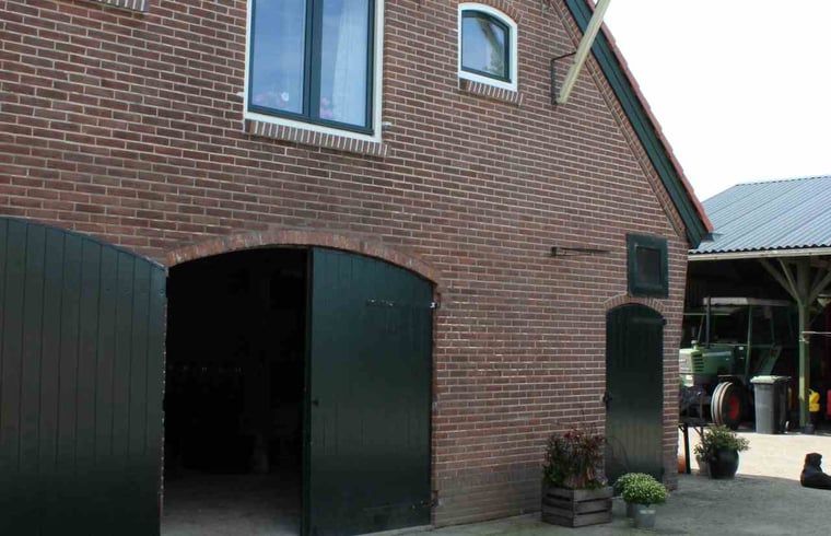 Buitenkant van Vakantiehuisje in Achterveld, Utrechtse Heuvelrug, met traditionele bakstenen en groene deuren.