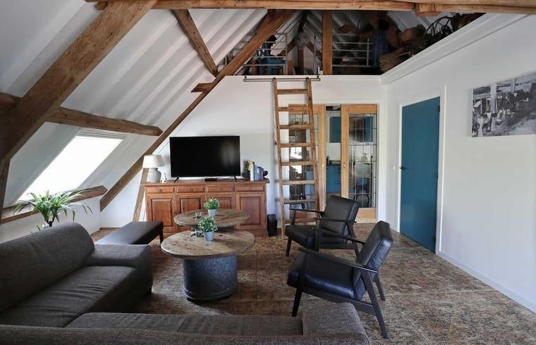 Moderne trap en wasruimte in Vakantiehuisje in Achterveld, Utrechtse Heuvelrug, met houten en metalen elementen.