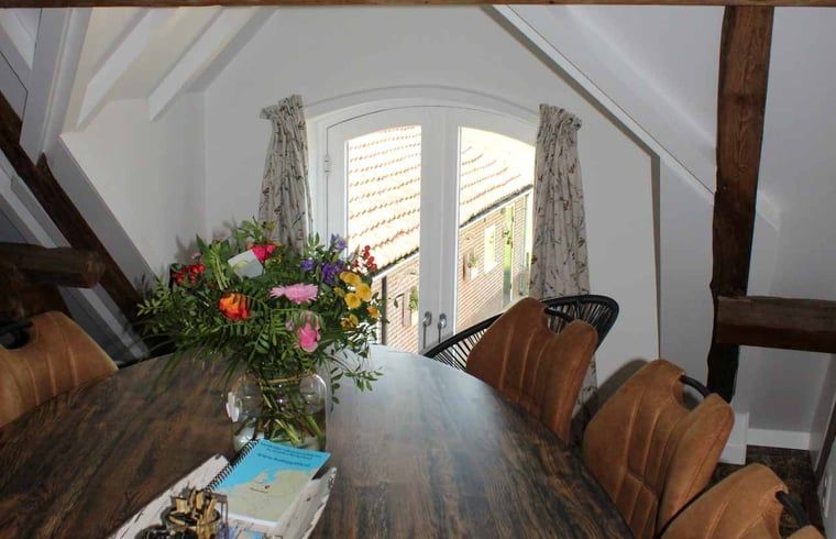 Stijlvolle eetkamer in Vakantiehuisje in Achterveld, Utrechtse Heuvelrug, met houten tafel en moderne inrichting.