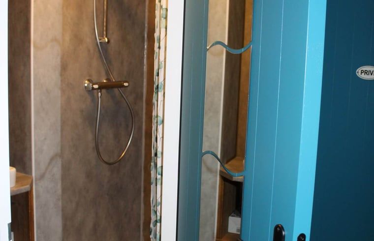 Comfortabele zithoek in Vakantiehuisje in Achterveld, Utrechtse Heuvelrug, met uitzicht op de tuin en houten ladder.