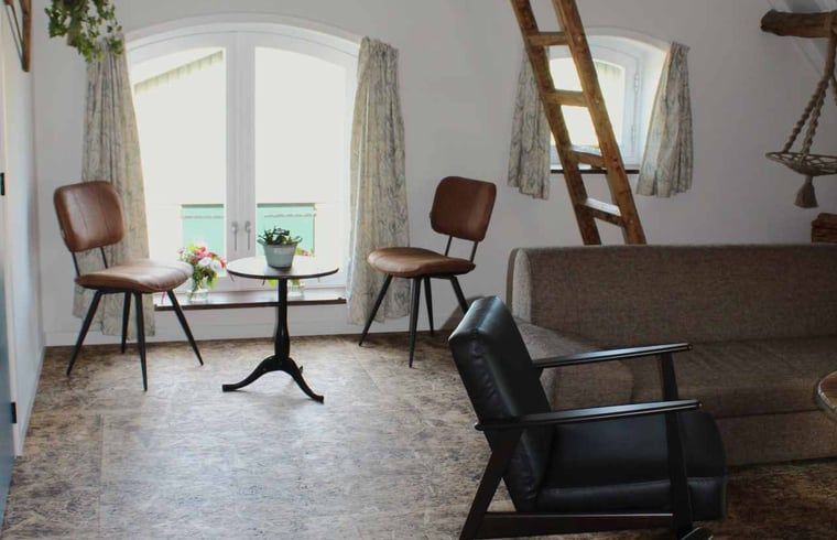 Gezellige woonkamer met houten meubels in Vakantiehuisje in Achterveld, Utrechtse Heuvelrug, Utrecht.