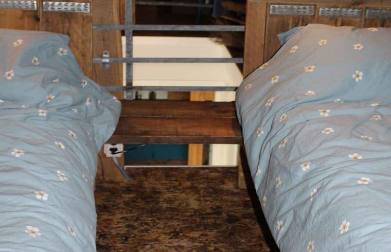 Gezellige slaapkamer met houten balken in Vakantiehuisje in Achterveld, Utrechtse Heuvelrug, Utrecht.