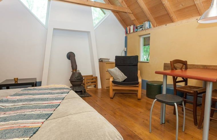 Interieur van vakantiehuis in Leerdam, Utrecht met houtkachel en eethoek.