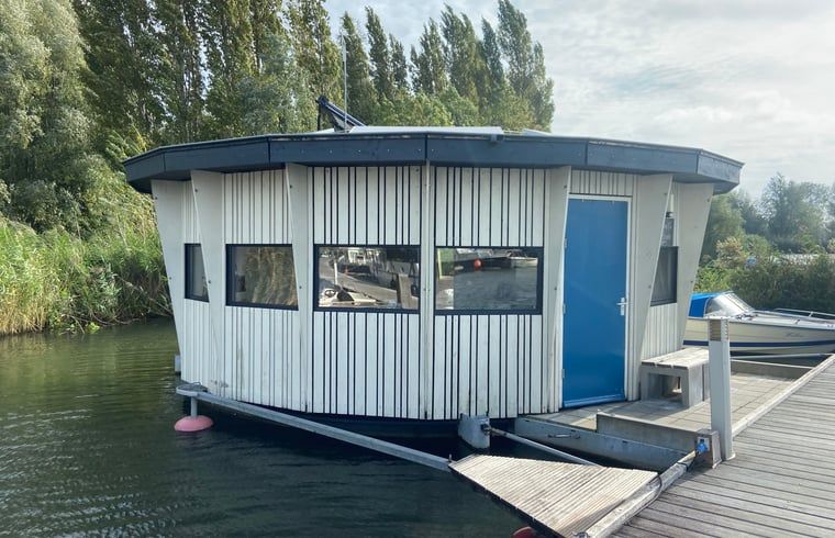 Huisje in IJsselstein, a unique waterfront vacation rental in Utrecht, offers a serene lodging experience in a picturesque setting.