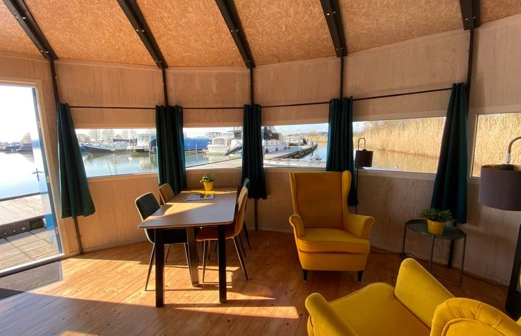Cozy indoor area of Cottage in IJsselstein, Utrecht overlooking the harbor. Perfect vacation home for relaxation and nature experience.