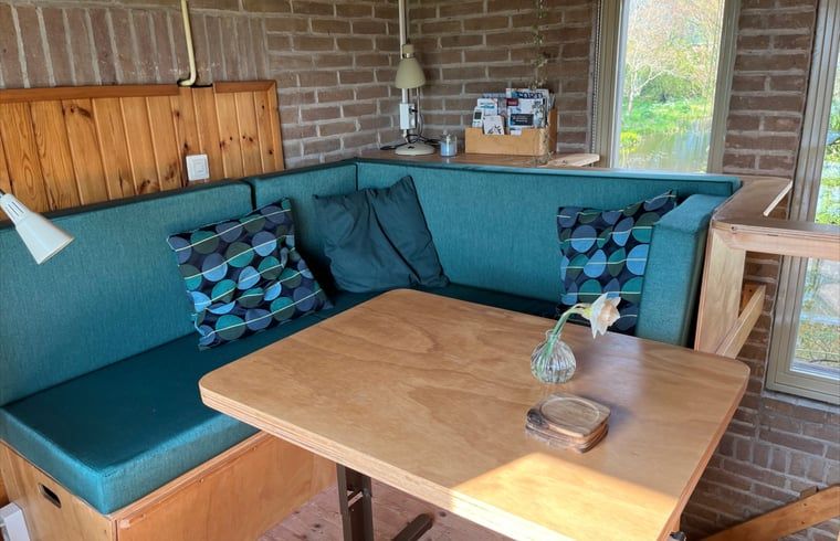 Gemuetliche Sitzecke im Ferienhaus in Schalkwijk, Utrecht. Komfortable Einrichtung mit Blick auf die Natur, ideal zum Entspannen.