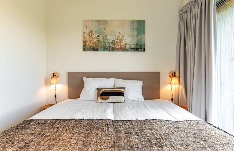 Cozy bedroom in Holiday home in Wissenkerke, Noord-Beveland, Zeeland with art on the wall.