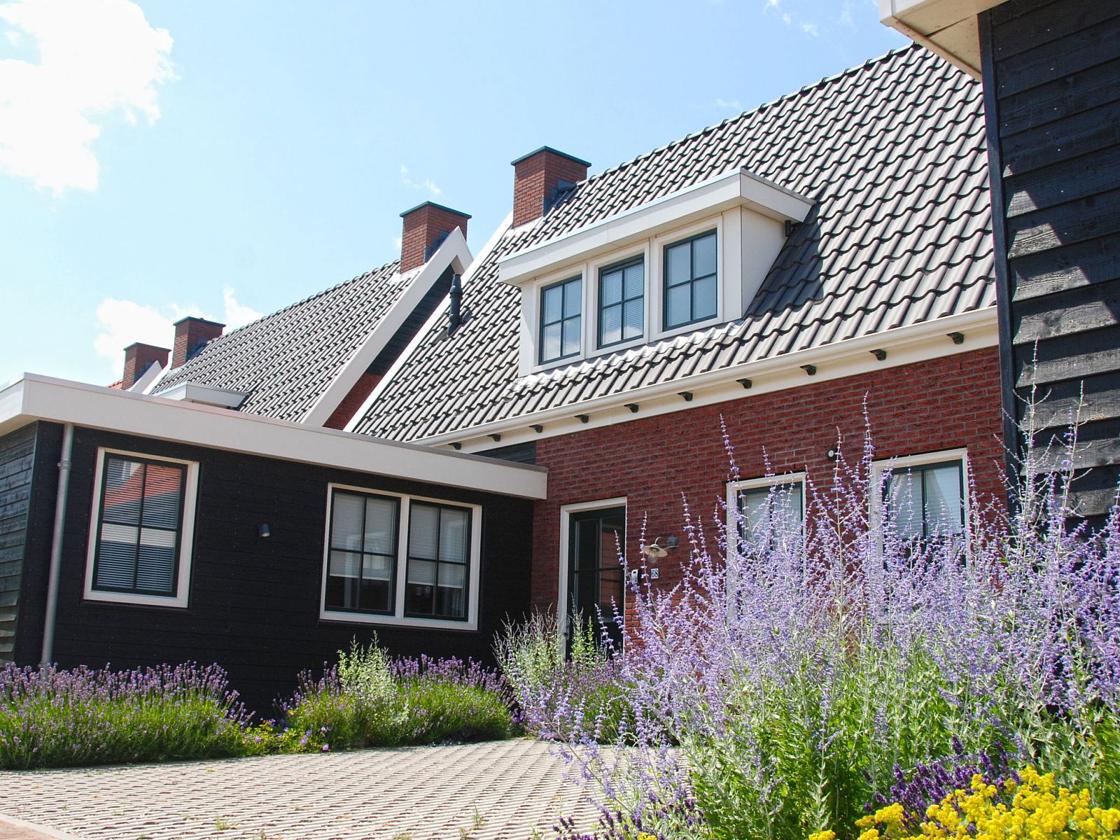 Exterior of Holiday Home Ganuenta in Colijnsplaat, North Beveland with colorful flowers and traditional architecture.