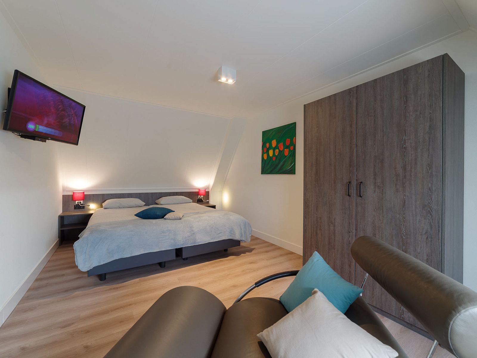 Cozy bedroom in Holiday Home Ganuenta, Colijnsplaat, North Beveland with television and art on the wall.