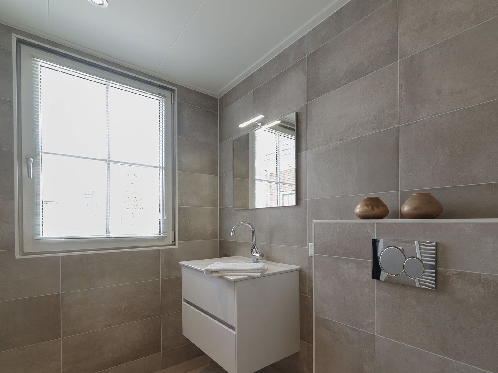 Stylish bathroom in Holiday Home Ganuenta, Colijnsplaat, North Beveland with large mirror and sink.