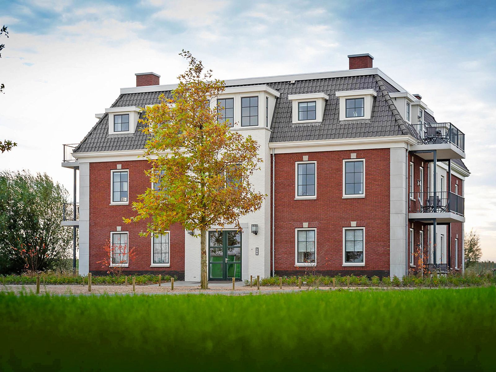 Rueckansicht des Apartments Ganuenta in Colijnsplaat, Nord-Beveland, mit gruener Umgebung und blauem Himmel.