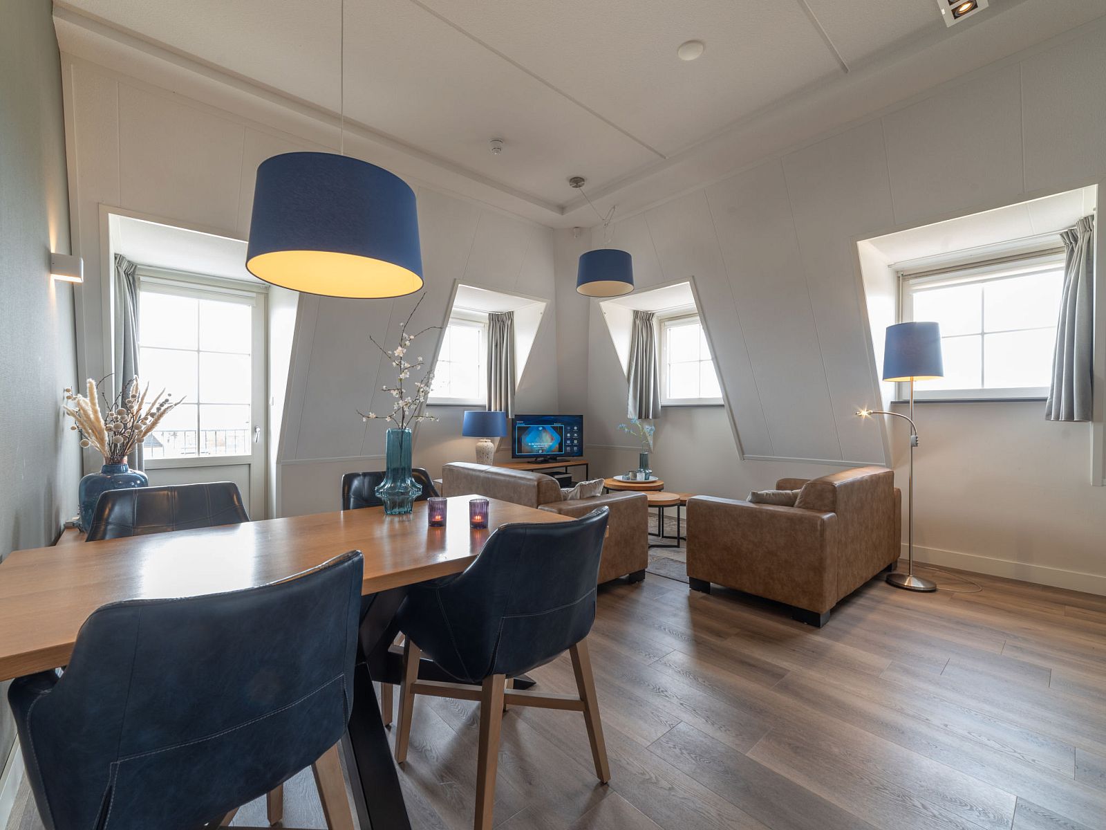 Essecke im Apartment Ganuenta, Colijnsplaat, Noord-Beveland, mit stilvollen Stuehlen und stimmungsvoller Beleuchtung.