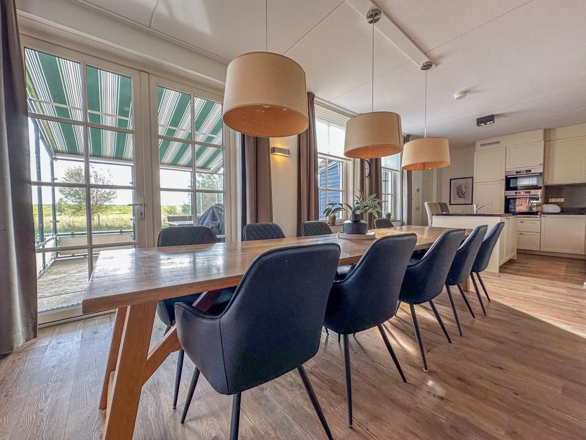 Ruime eetkamer in vakantiehuis Dune Design 39 in Colijnsplaat, Noord-Beveland, met uitzicht op het terras en de natuur van Zeeland.