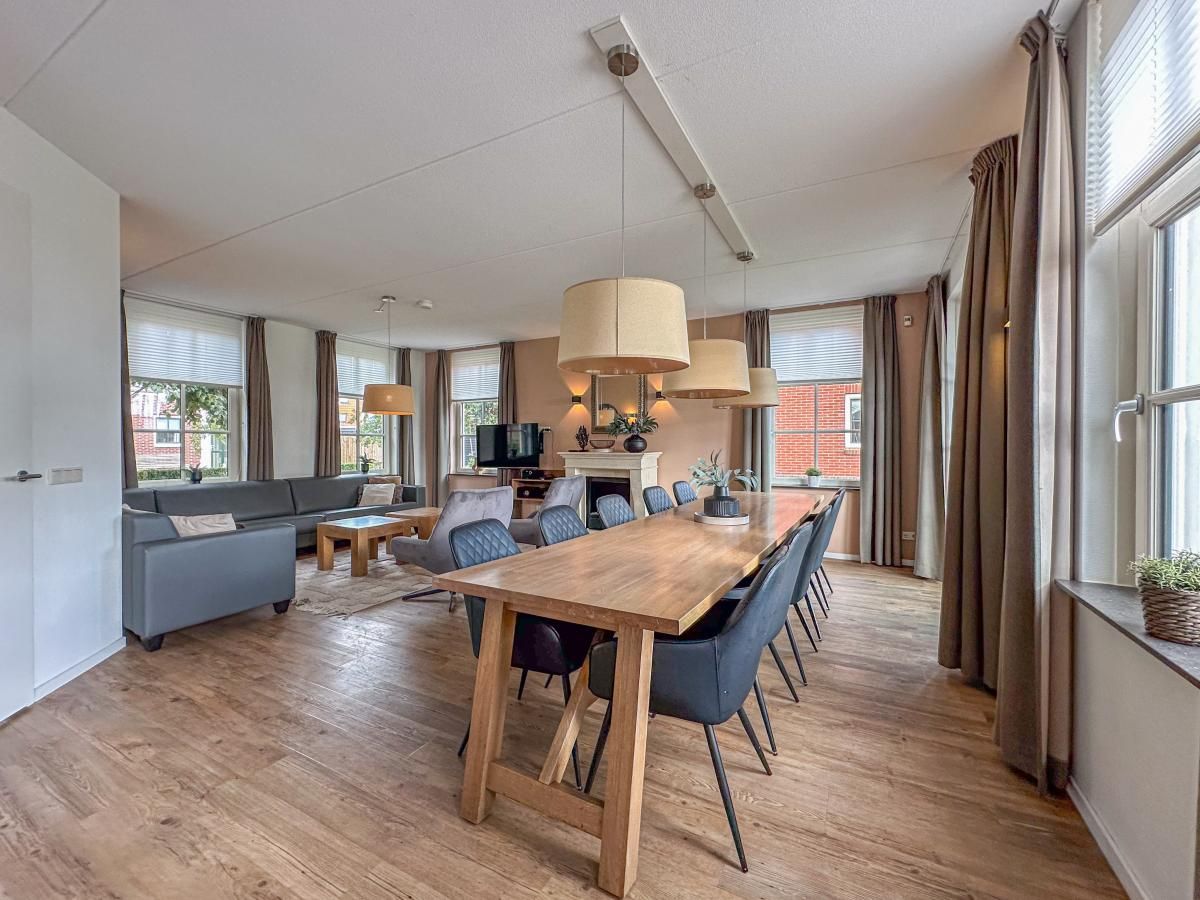 Stijlvolle woonkamer van vakantiehuis Dune Design 39 in Colijnsplaat, Noord-Beveland, Zeeland met ruime eethoek en gezellige zithoek.