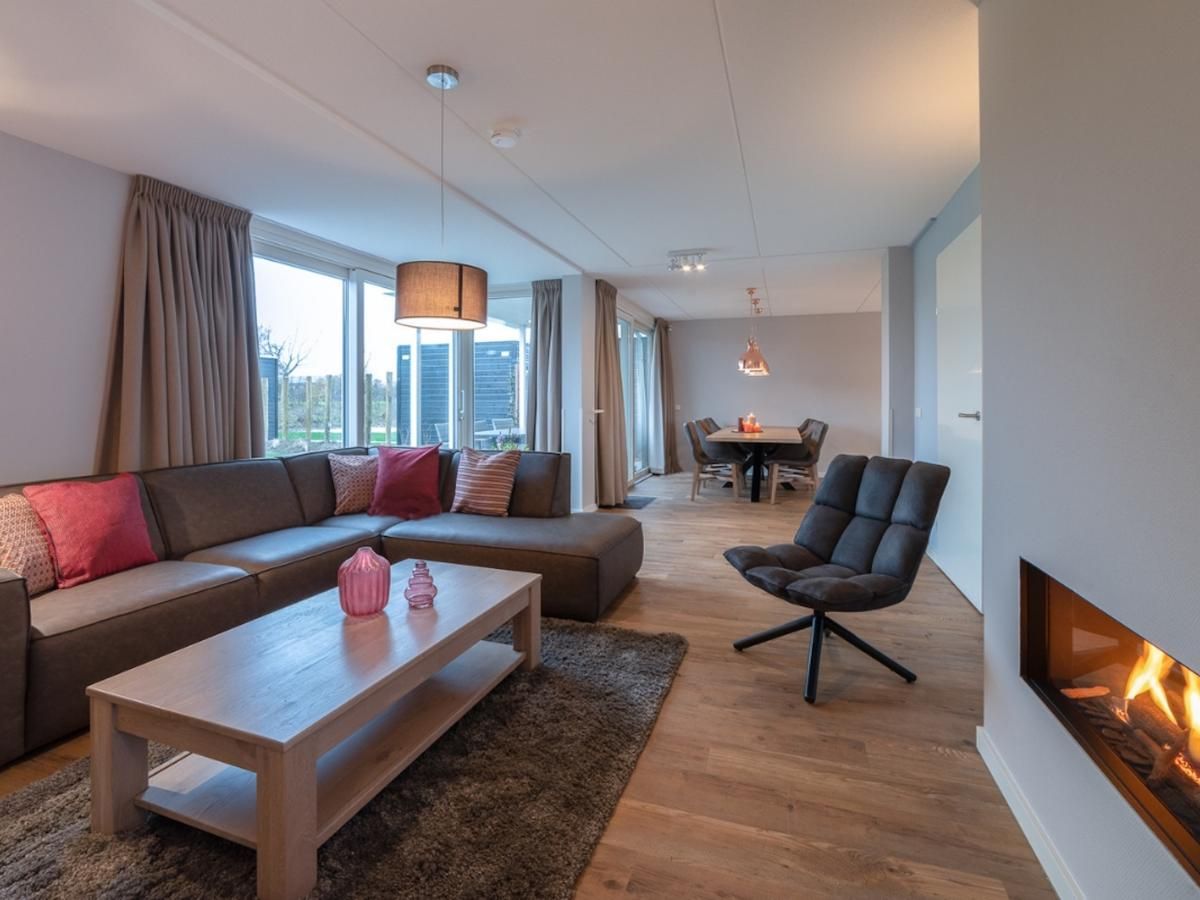 Gezellige woonkamer met open haard in Coast Calm 71 vakantiehuis, Colijnsplaat.