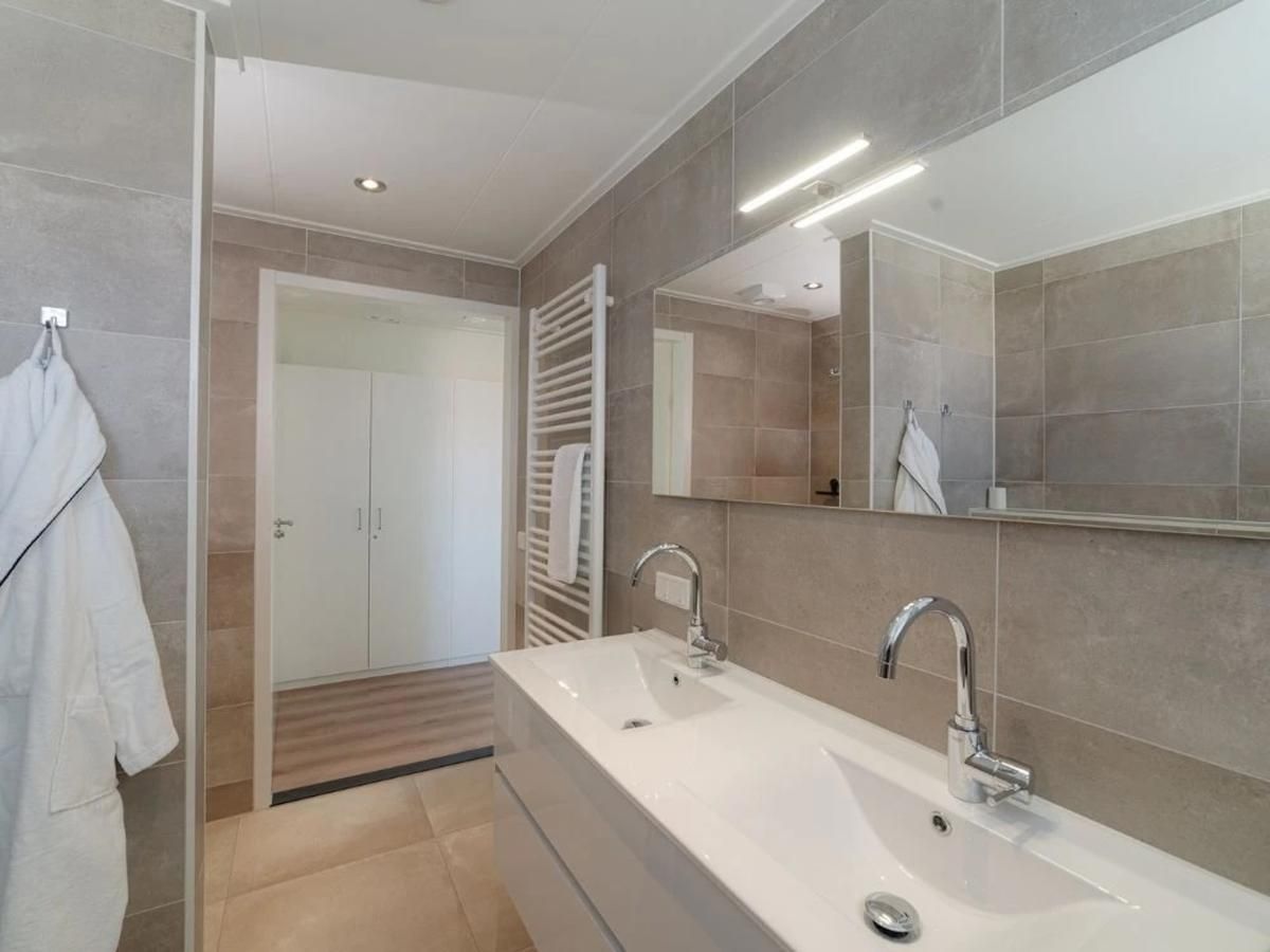 Luxe badkamer met dubbele wastafel in Coast Calm 71 vakantiehuis, Zeeland.