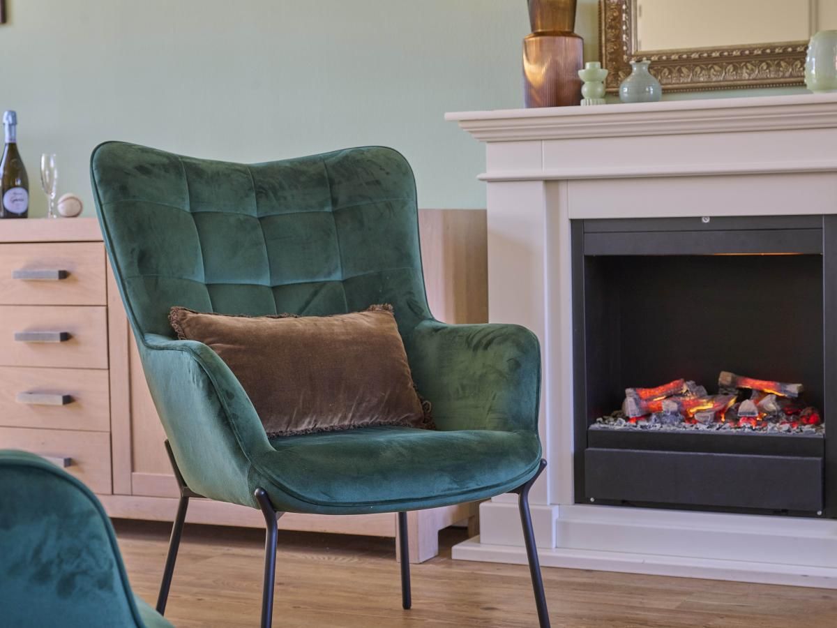 Knusse open haard en luxe fauteuil in vakantiehuis Ocean Ease 49, gelegen in Colijnsplaat, Noord-Beveland.