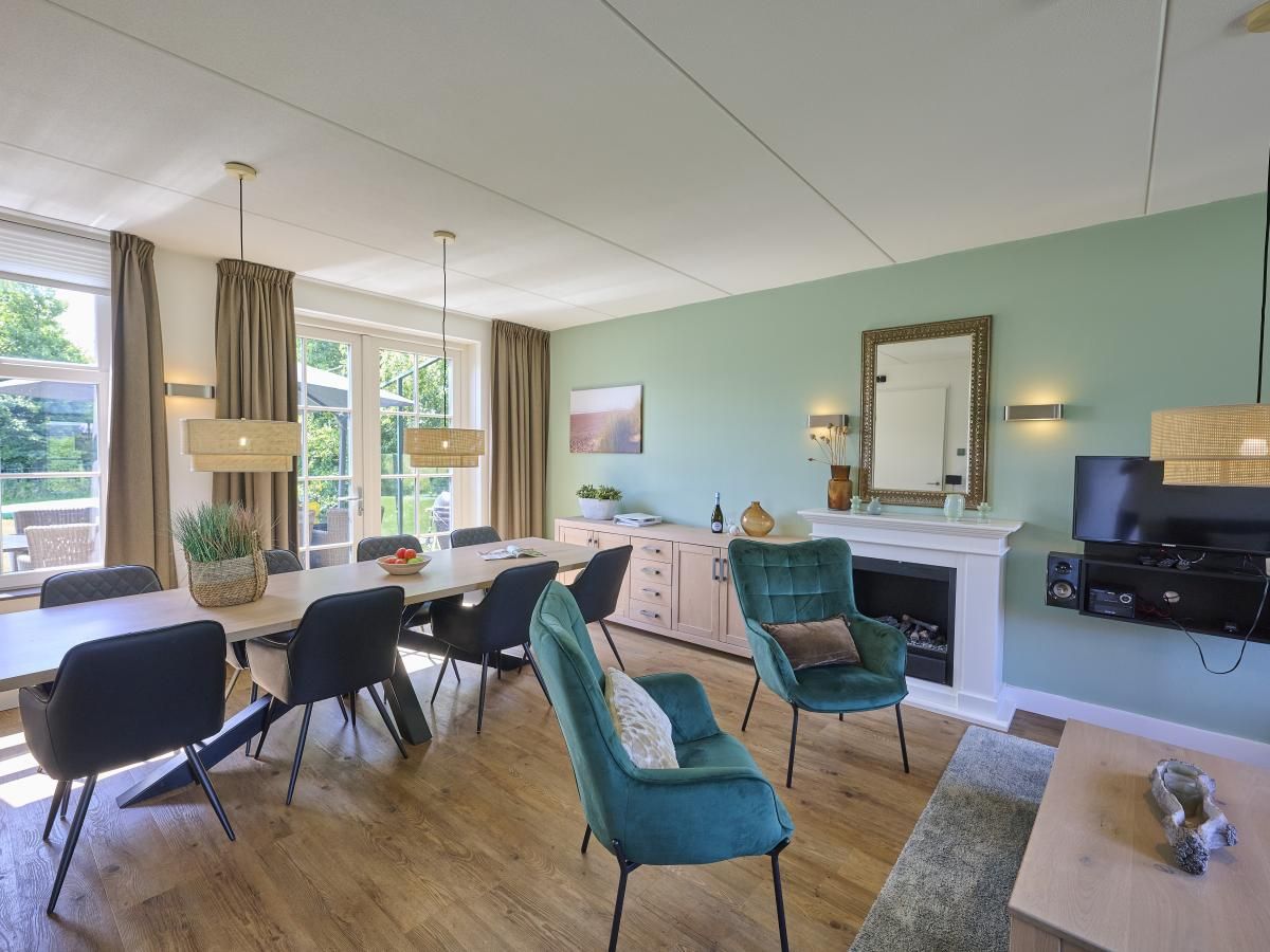 Ruime eetkamer in Ocean Ease 49, Colijnsplaat, Zeeland, met grote tafel en veel natuurlijk licht.