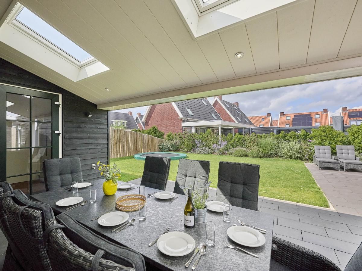 Ruime tuin met trampoline bij Beach deluxe vakantiehuis in Colijnsplaat, Noord-Beveland, Zeeland.