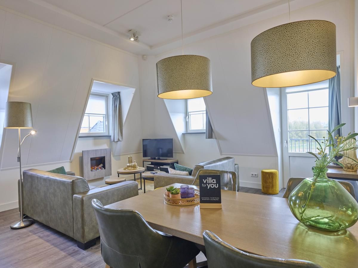 Cozy living room of Sauna Zee 27H vacation home in Colijnsplaat, North Beveland, with modern decor and lots of natural light.