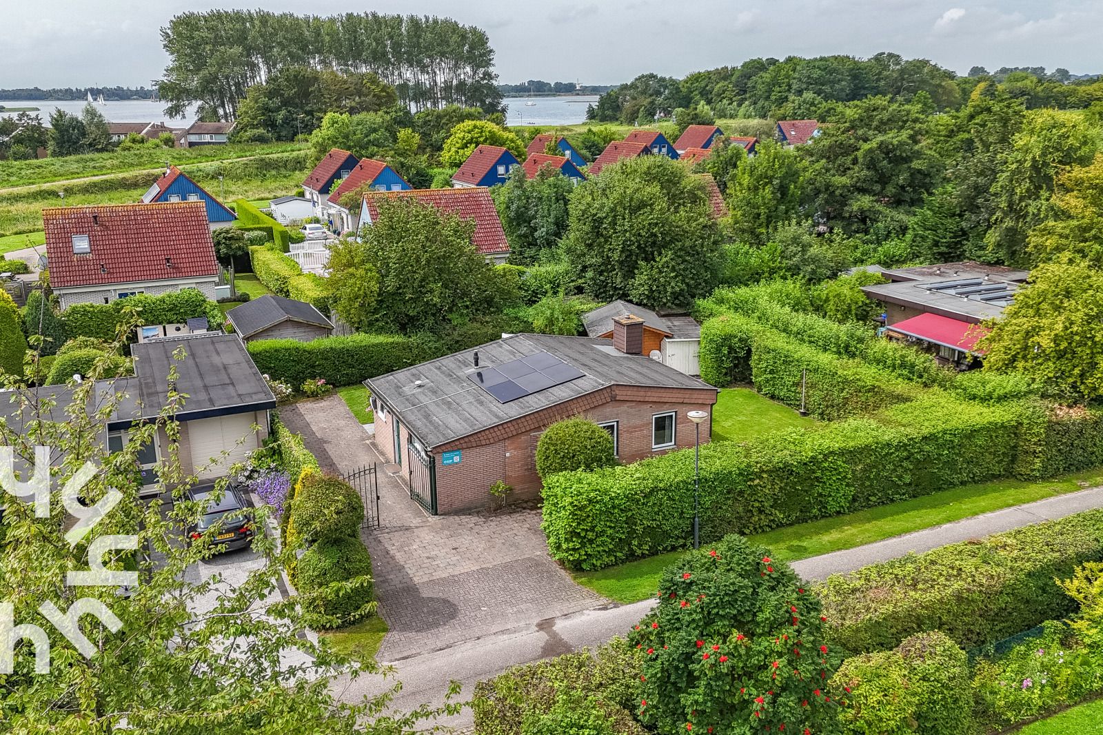 Eingang zum Ferienhaus ZE1121 in Kamperland, Zeeland mit bluehenden Blumen.