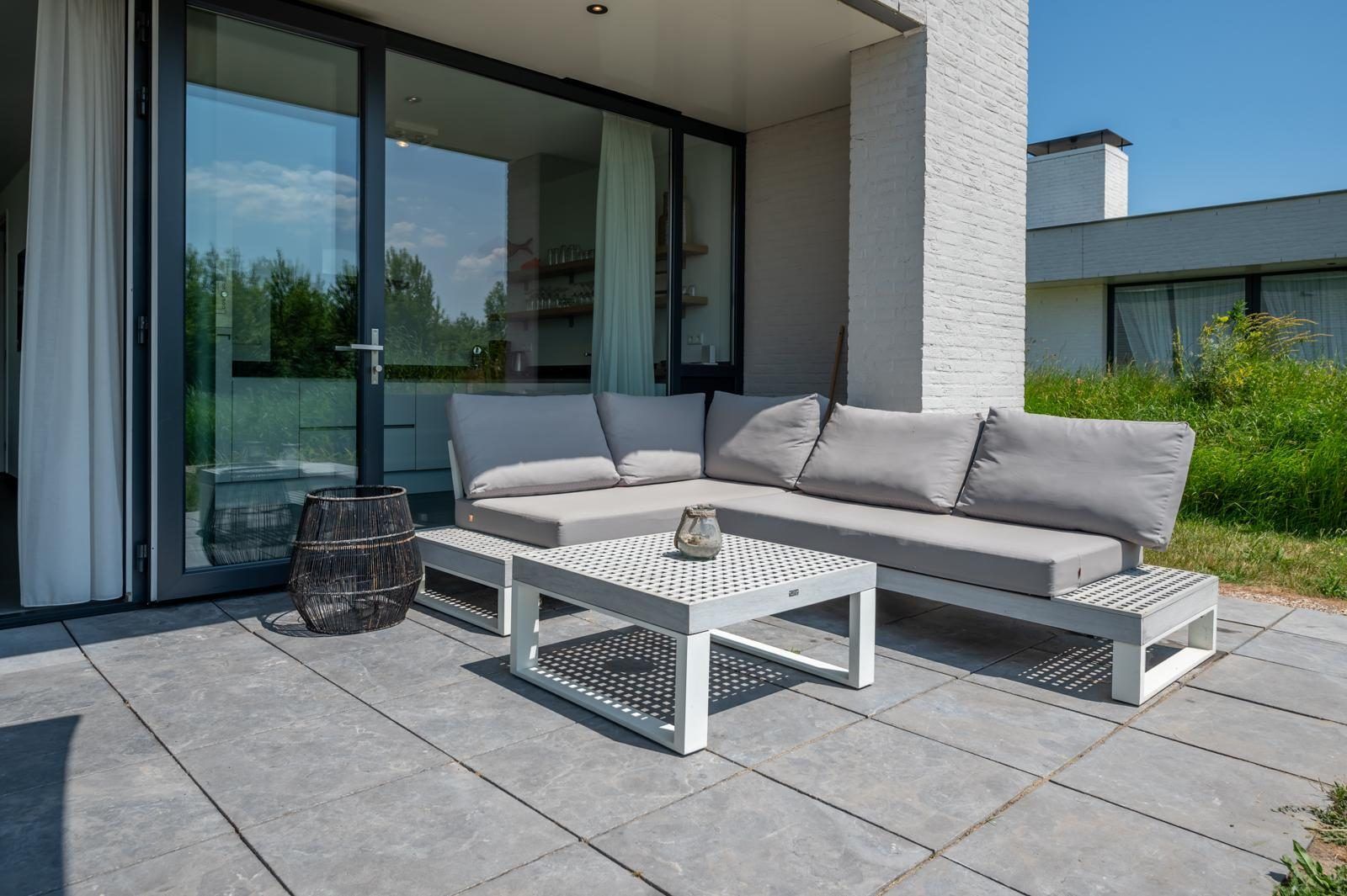 Gezellig terras met loungebank in Duinvallei 32, vakantiehuis in Kamperland, Zeeland.