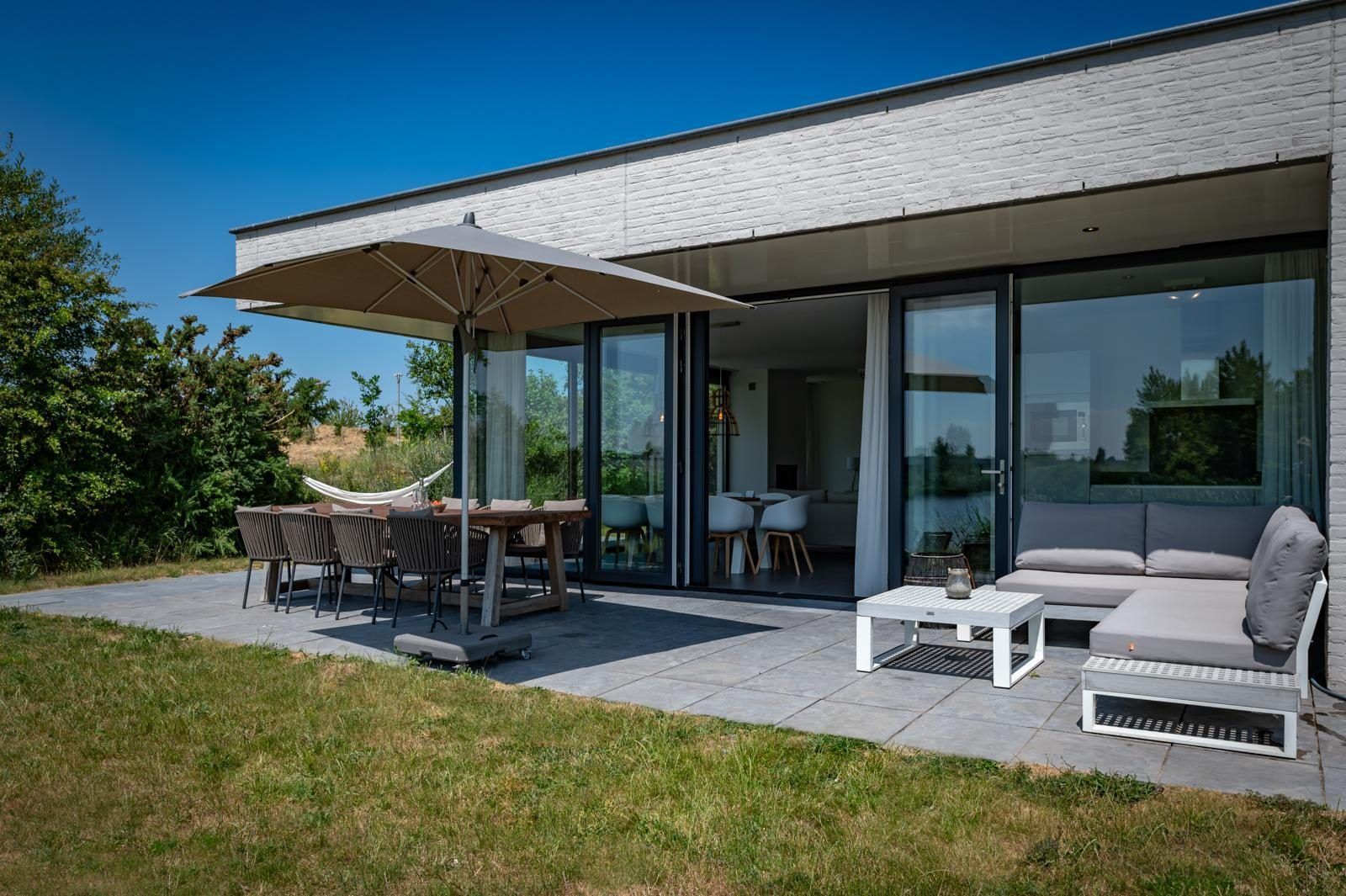 Ruim terras met eethoek en parasol in Duinvallei 32, vakantiehuis in Kamperland, Zeeland.