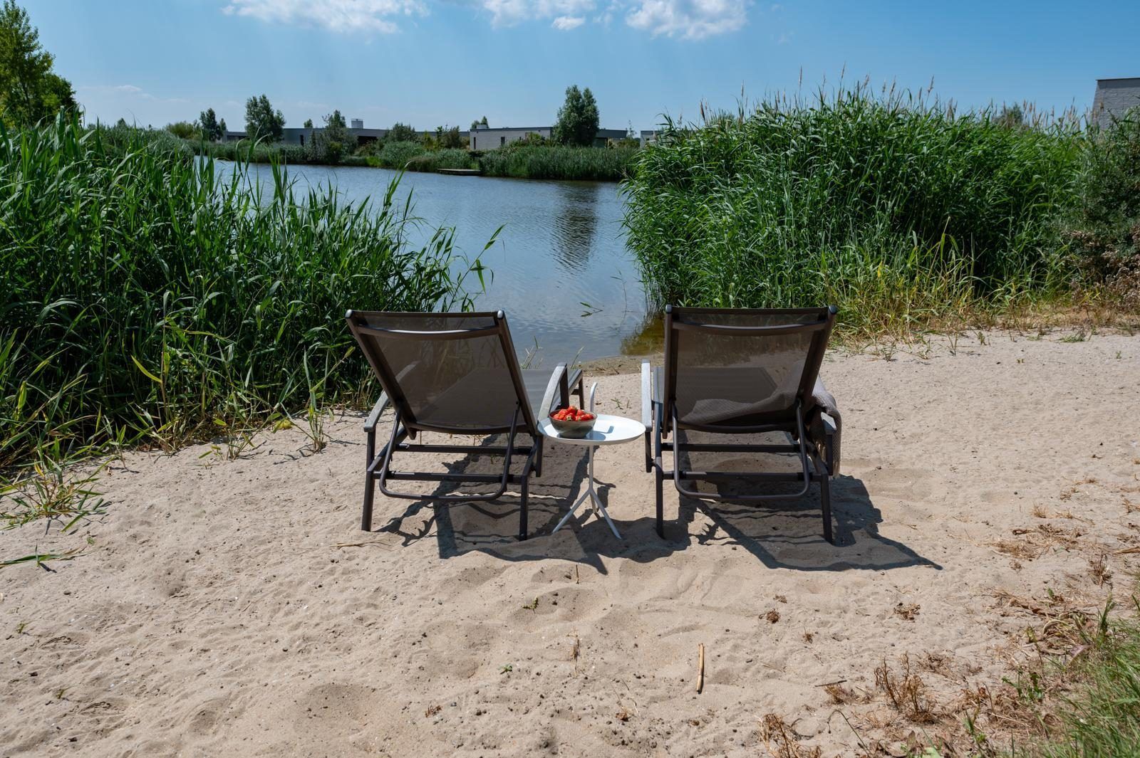 Zonnig strandje aan het water in Duinvallei 32, vakantiehuis in Kamperland, Zeeland.