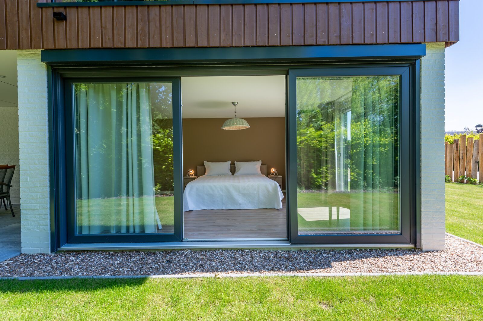 View of bedroom from garden in bungalow Kastanjelaan 2 | Ruiterplaat, Kamperland, with large windows.