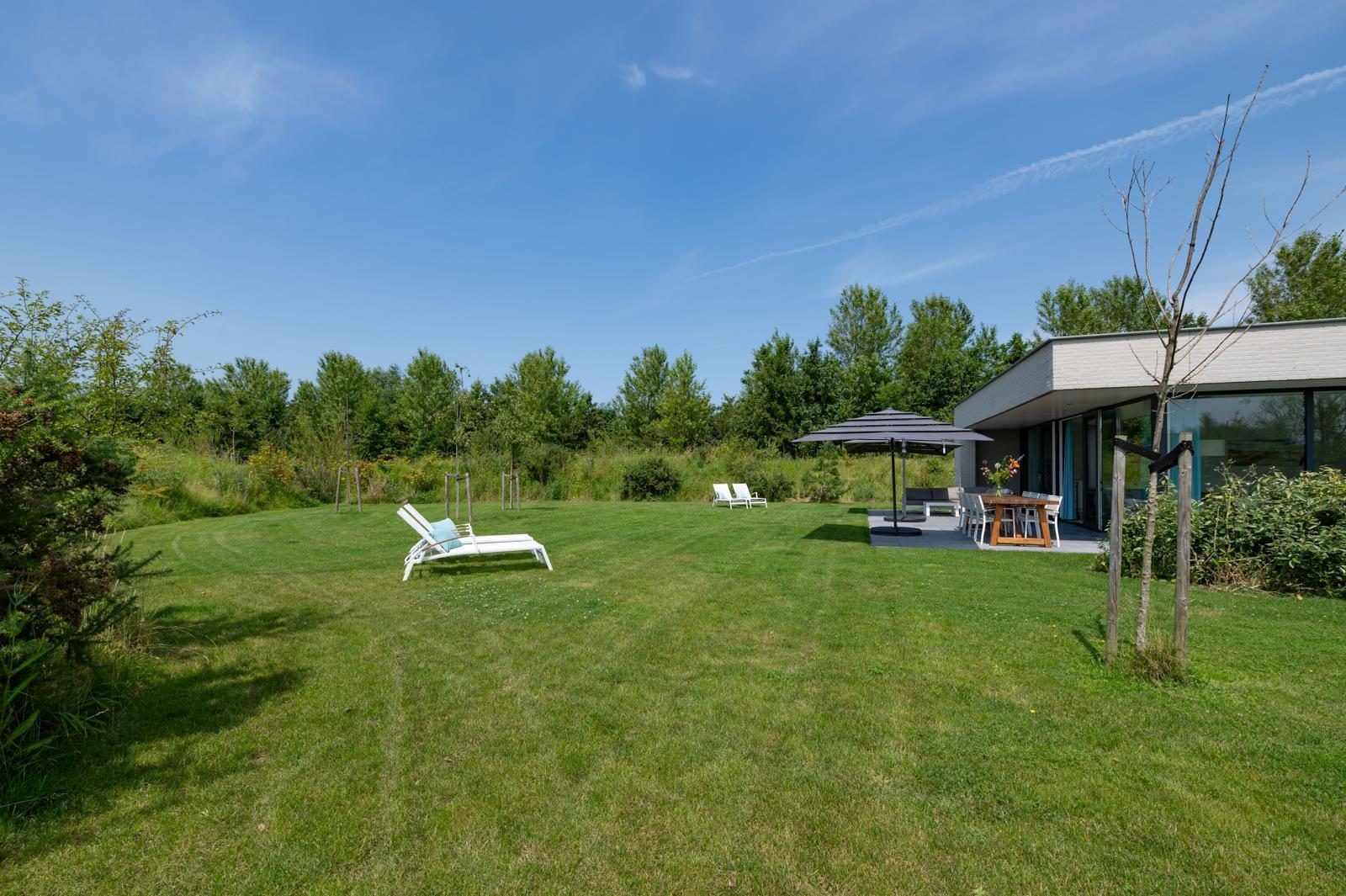 Grosser Garten bei Waterline 25 | De Groote Duynen, Ferienhaus in Kamperland, Noord-Beveland, mit Liegestuehlen und Blick ins Gruene.