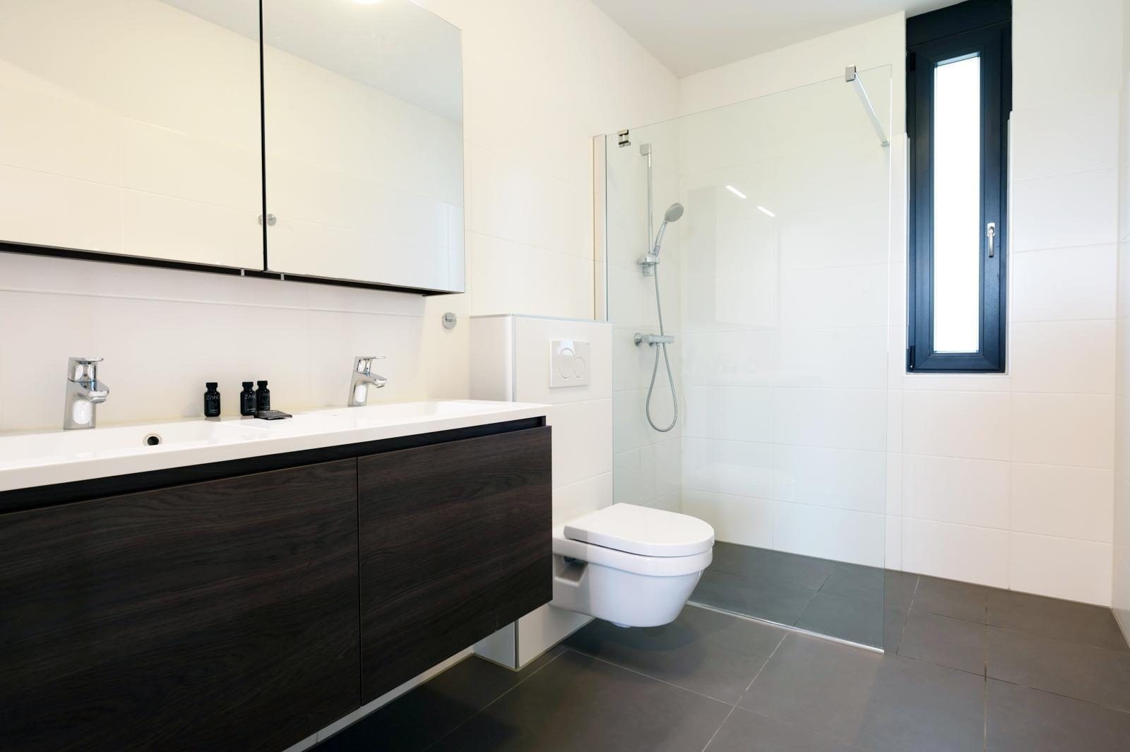 Stijlvolle badkamer in Duinvallei 39, De Groote Duynen, Kamperland, met een moderne douche en wastafel.