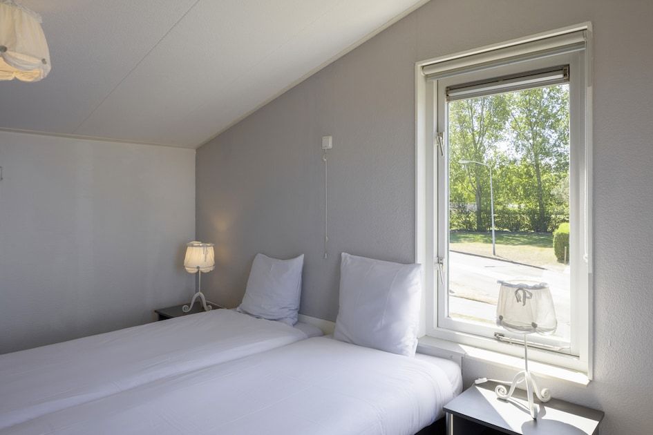 Attraktives Schlafzimmer im NE-Bungalow, Kamperland, mit einem bequemen Bett und Kleiderschrank fuer einen erholsamen Aufenthalt in Noord-Beveland, Zeeland.