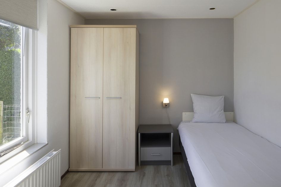 Attraktives Schlafzimmer im Bungalow NE, Kamperland, Noord-Beveland, mit Blick auf die Natur von Zeeland.