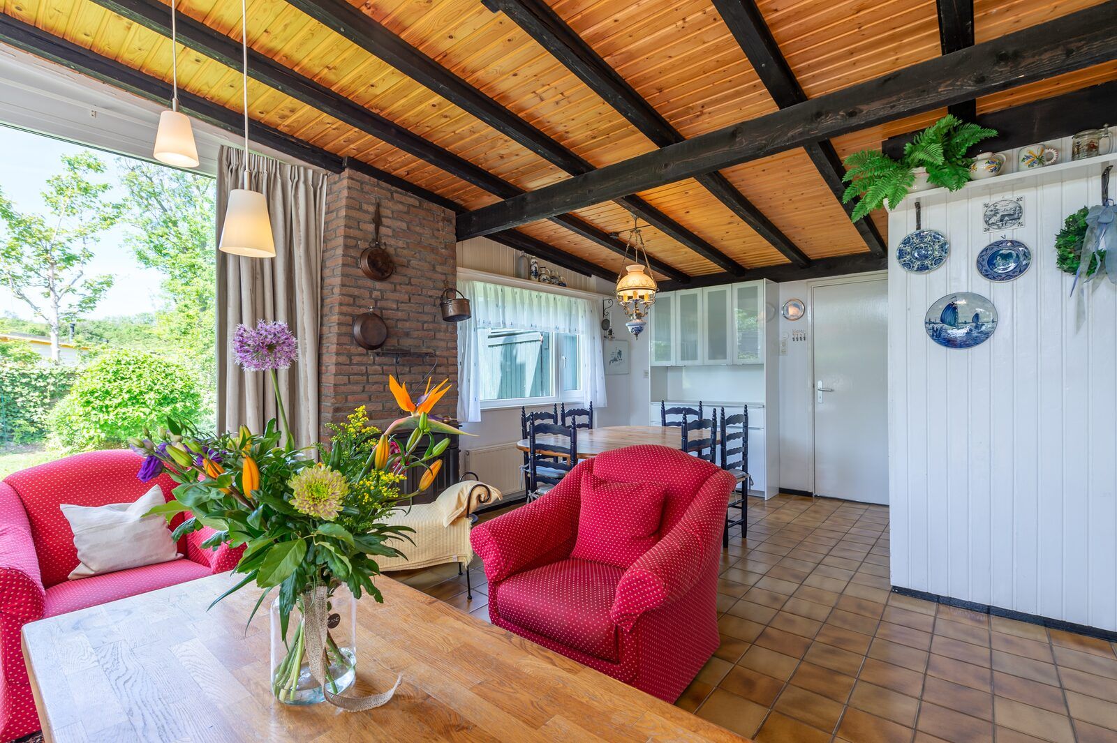 Helles Esszimmer im Ferienhaus Lark Avenue 15, Kamperland, mit Holzdecke und bunten Blumen.