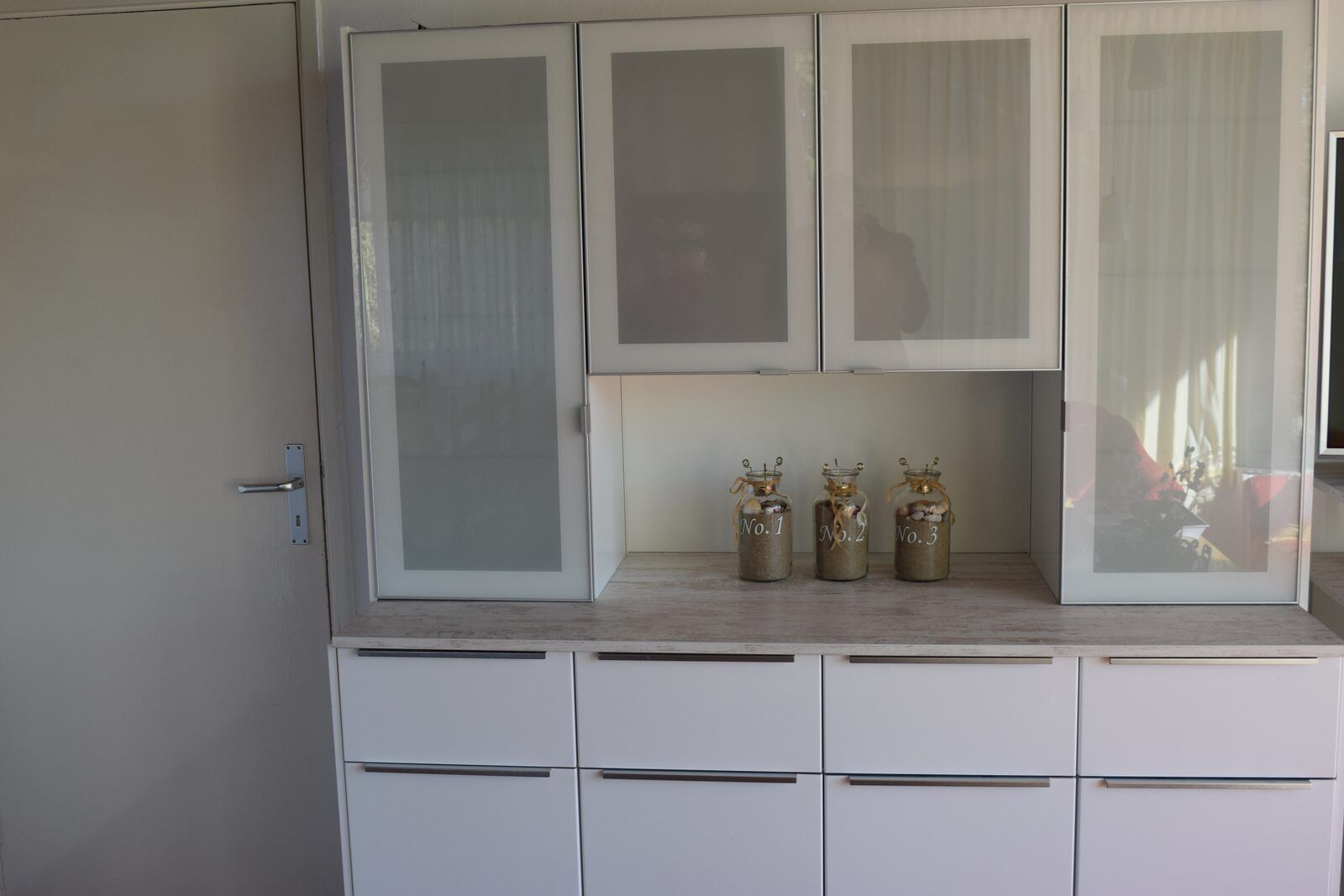 Modernes Kuechengeschaeft im Ferienhaus Lark Avenue 15, Kamperland, mit Glasvitrinen und dekorativen Toepfen.