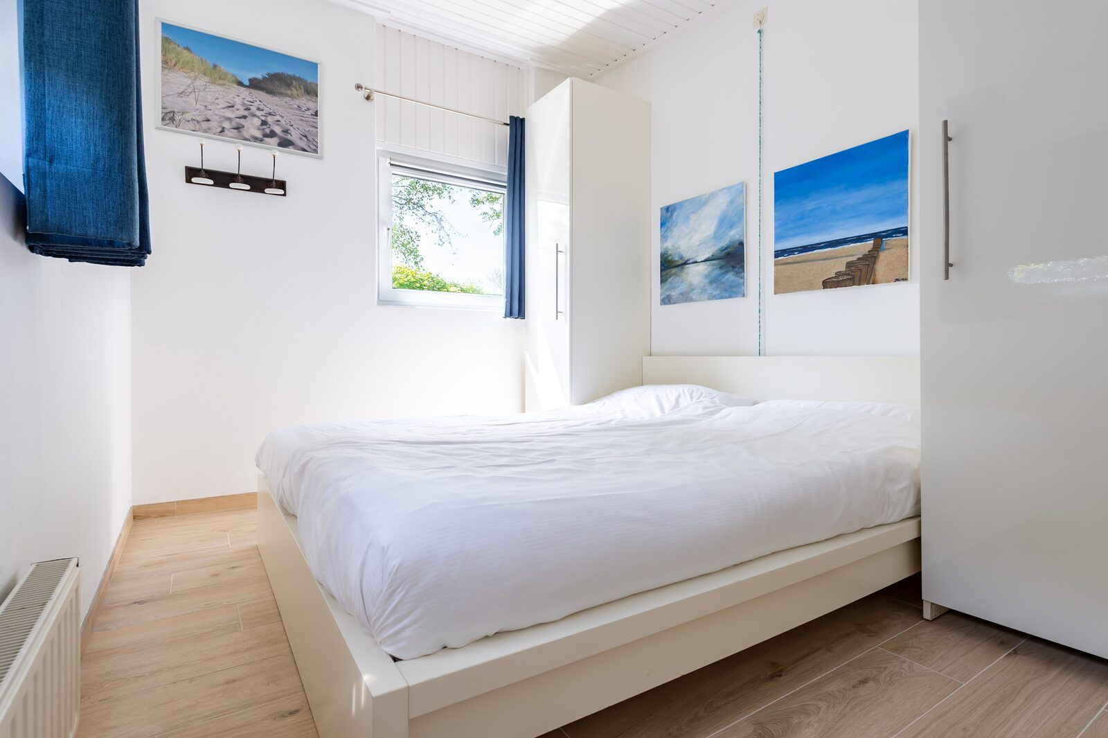 Zweites Schlafzimmer im Ferienhaus Lark Avenue 15, Kamperland, mit weisser Einrichtung und Blick in die Natur.