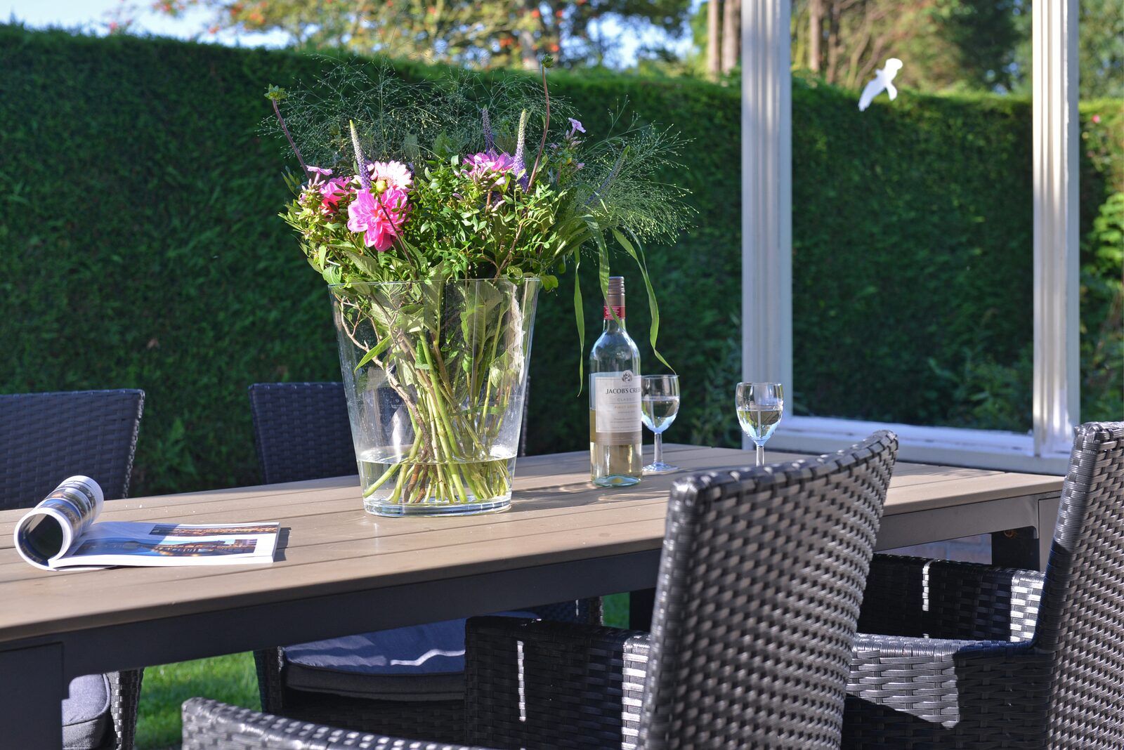 Gemuetliche Terrasse mit Blumen und Wein in der Saturnuslaan 14 Rancho Grande in Kamperland, ideal fuer entspannte Abende.