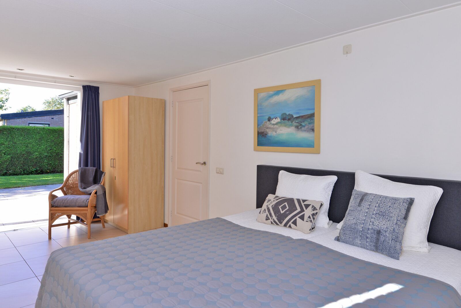 Schlafzimmer mit grossem Bett und Kunst an der Wand in Saturn Avenue 14 Rancho Grande, Ferienhaus in Kamperland, Nord-Beveland.