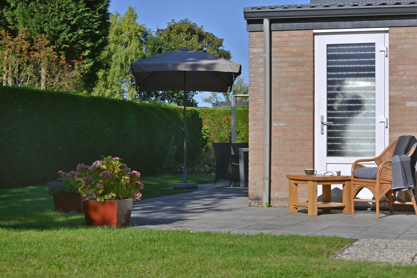 Gruener Garten mit Terrasse und Blumen in Saturnuslaan 14 Rancho Grande, Ferienhaus in Kamperland, Zeeland.