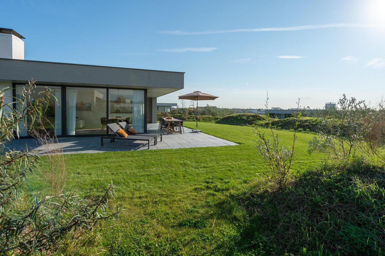 Vorderseite von Duinvallei 43, Ferienhaus in Kamperland, mit schlichtem Design und gruener Umgebung.