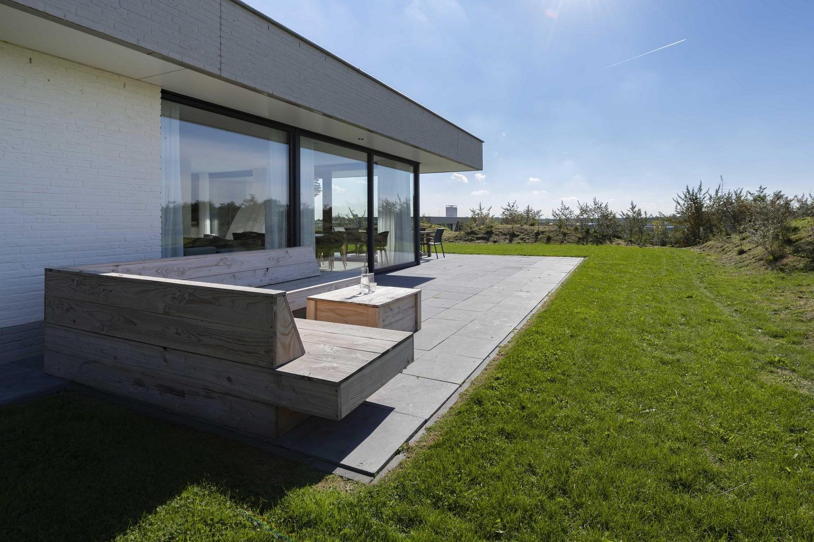 Seitenansicht von Duinvallei 43, Ferienhaus in Kamperland, mit Terrasse und Liegestuehlen.