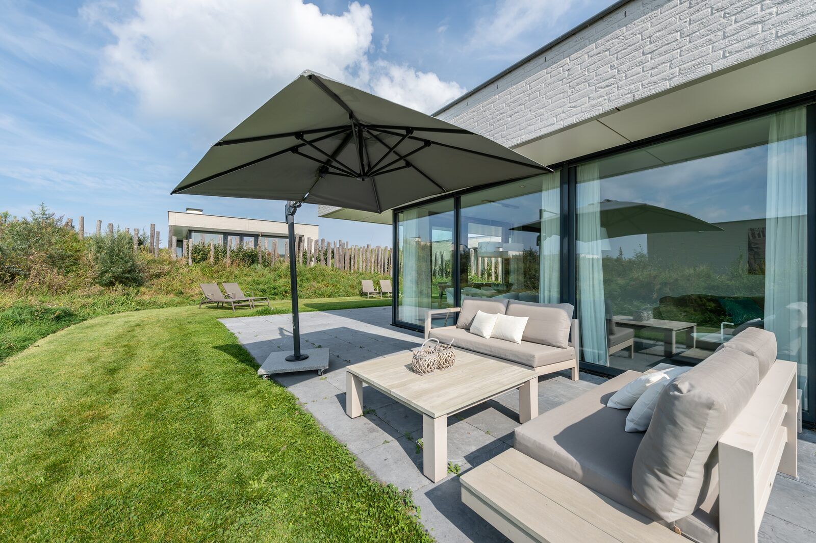 Moderne Kueche des Ferienhauses Duinvallei 19 in Kamperland mit schlichten weissen Schraenken